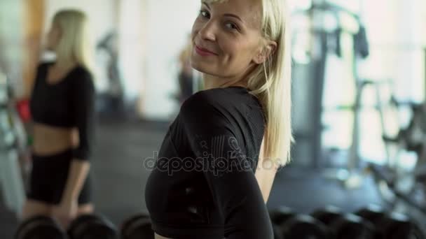 Portret van een jonge vrouw trainer in de sportschool — Stockvideo