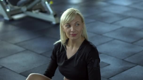 Mujer joven descansando entre ejercicios en el gimnasio — Vídeos de Stock