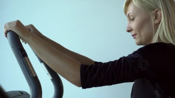 Ung kvinna utövar på en stepper lärling — Stockvideo