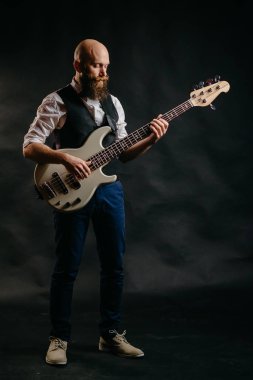 sakallı adam siyah bir arka plan üzerinde gitar çalmak