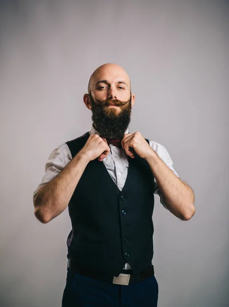 Bearded man adjusts a bow tie — Stock Photo, Image