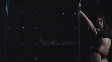 genç kadın bir dans pole üzerinde gerçekleştirir.