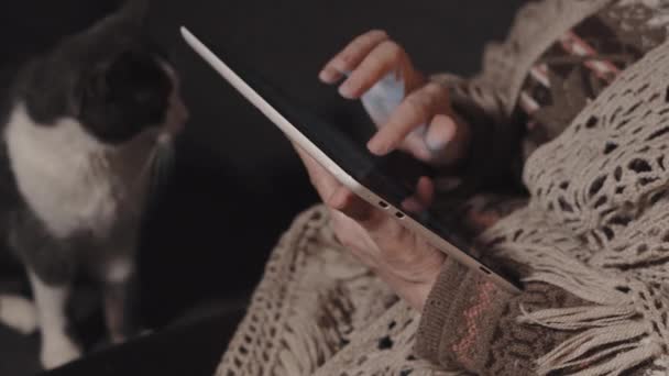 Пожилая женщина пользуется планшет на дому — стоковое видео