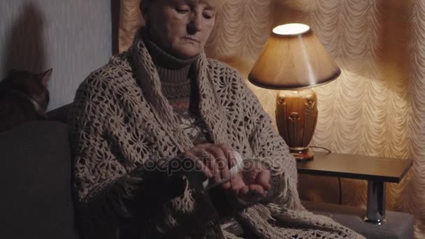 Пожилая женщина вынимает таблетки из бутылки — стоковое видео