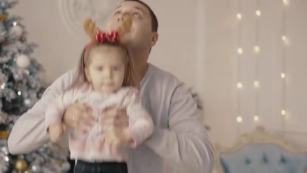 Küçük kız annesi ve babası Noel ağacı yakınındaki ile oynanır — Stok video
