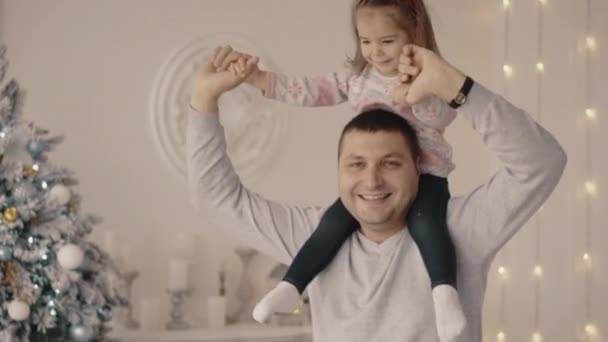 Meisje wordt gespeeld met haar vader en moeder in de buurt van de kerstboom — Stockvideo