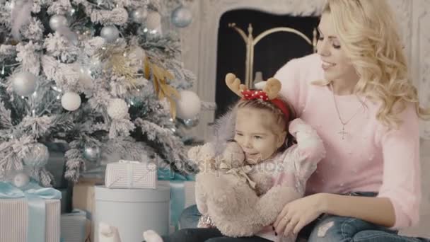 Joven madre con su hija sentada cerca del árbol de Navidad — Vídeo de stock