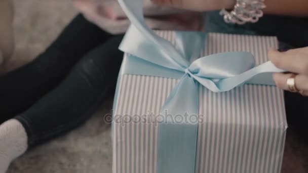 Niña abre una caja con un regalo de Navidad — Vídeo de stock