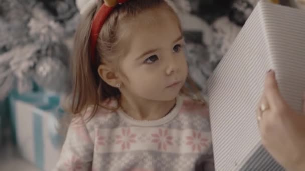 Malá holčička se dívá na vánoční dárky s její matkou — Stock video
