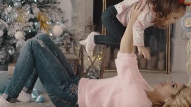 genç anne ile kızı Noel ağacı yakınındaki çalış