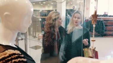 iki kadın Store mağazası yakınındaki kıyafetler seçin