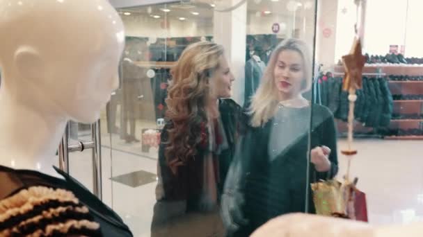 Two women choose clothes in the store near the storefront — Stock Video