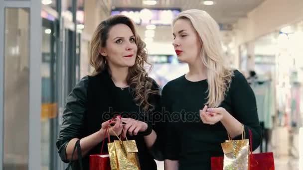 Två unga kvinnor kommunicera under shopping på köpcentret — Stockvideo