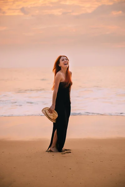 Young woman is standing on the beach and laughing — Stock Photo, Image
