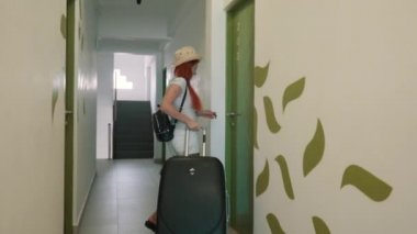 mutlu kadın bir bavulla otel odasında girer.