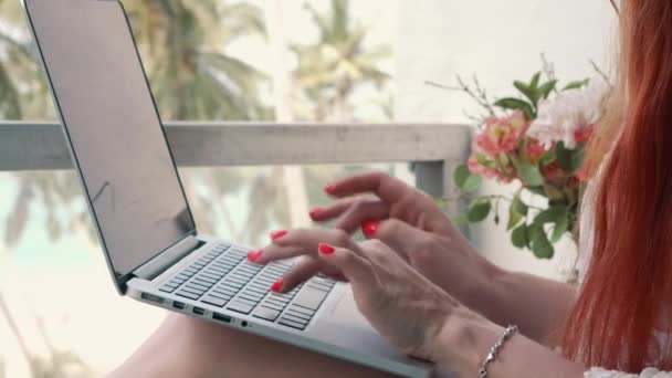 Mujer joven que trabaja en la computadora mientras se relaja en los trópicos — Vídeos de Stock