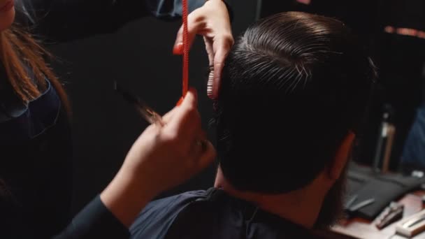 Jonge bebaarde man gesneden in de barbershop, close-up — Stockvideo