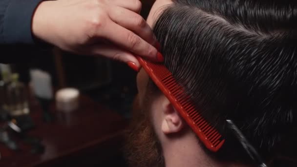 Jonge bebaarde man gesneden in de barbershop, close-up — Stockvideo