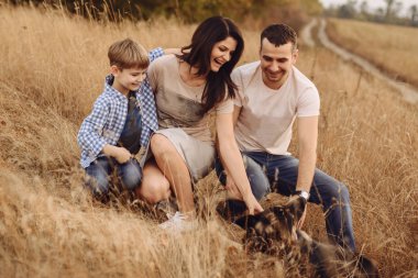 Annem ve babam açık havada köpeğiyle oynuyor