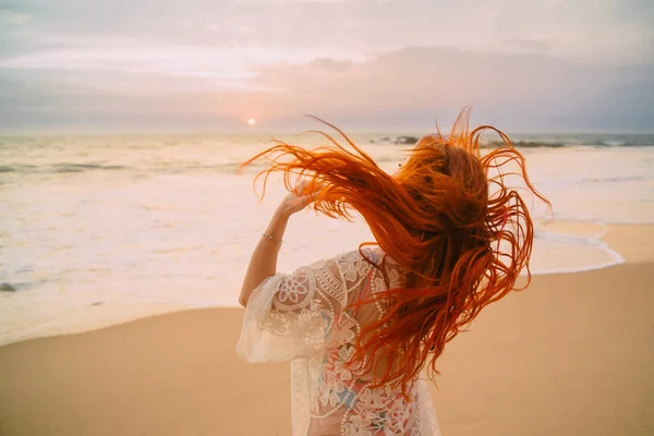 Молода руда жінка з літаючим волоссям на океані, вид ззаду — стокове фото