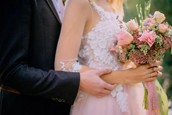 Mains de la mariée avec un bouquet de mariage, gros plan — Photo