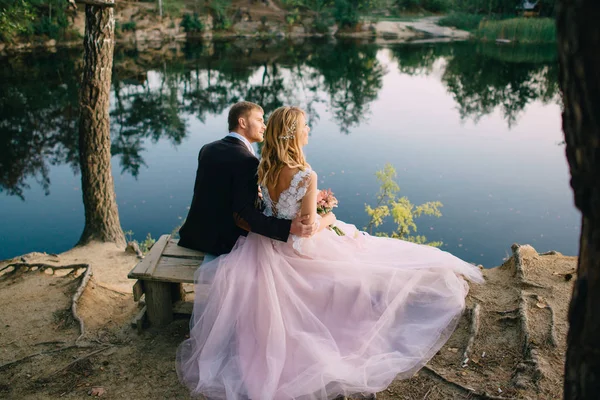 Jeunes mariés sur la rive du lac par une soirée d'été — Photo