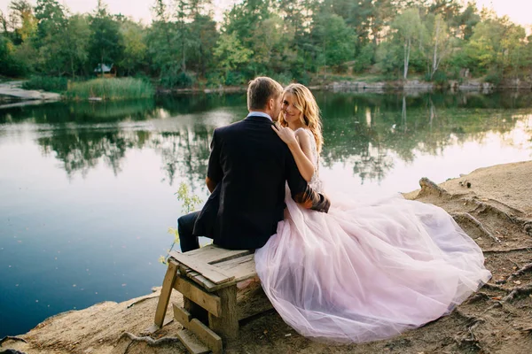 Recién casados en la orilla del lago en una noche de verano —  Fotos de Stock