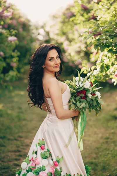 Portret van een jonge bruid in een bloeiende lila tuin — Stockfoto