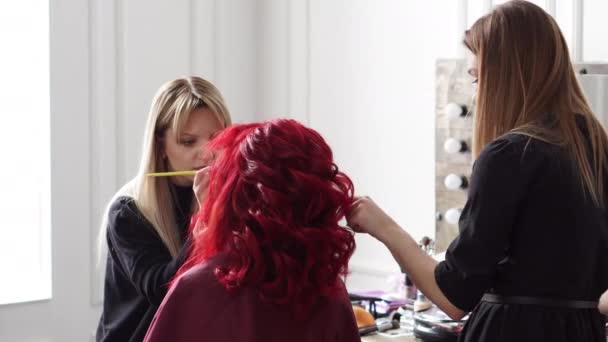Make-up artist och frisör tjänar klienten — Stockvideo