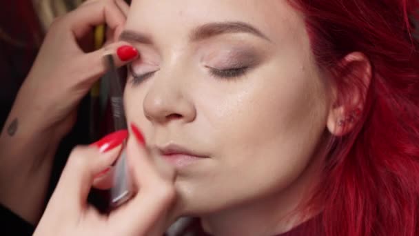 Make-up artist målar ögonlock till klienten i en skönhetssalong — Stockvideo