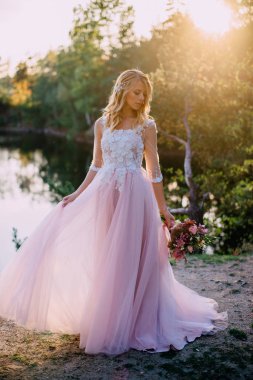 doğa arka plan üzerinde elinde bir buket ile güzel gelin duruyor