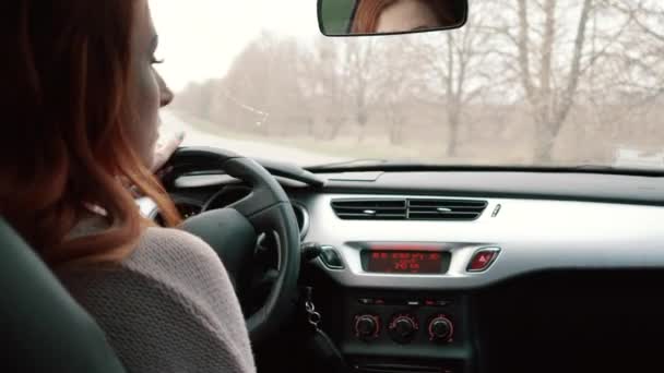 젊은 여성이 운전 자동차, 후면 보기 — 비디오