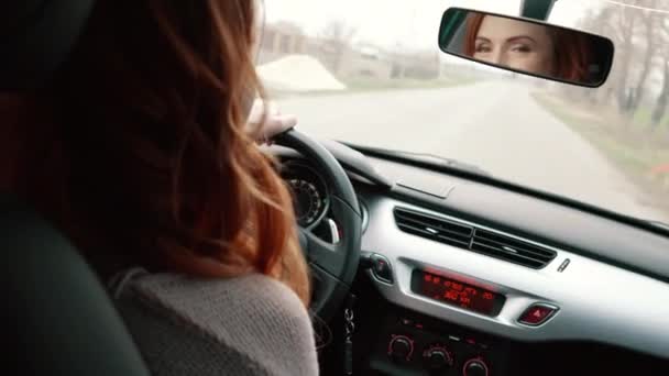 Νεαρή γυναίκα οδήγηση αυτοκινήτου, πίσω όψη — Αρχείο Βίντεο