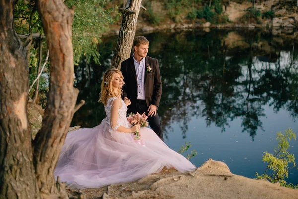 Jeunes mariés sur la rive du lac par une soirée d'été — Photo