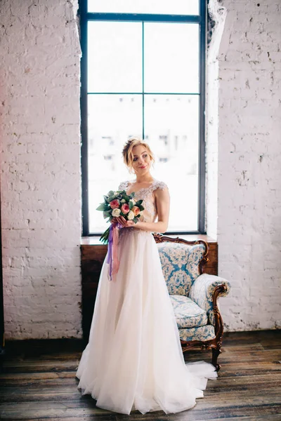 Porträt einer jungen schönen Braut auf einem Dachboden vor einem Fenster — Stockfoto