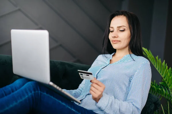 Mulher jovem insere detalhes do cartão de crédito no laptop para pagamento online — Fotografia de Stock