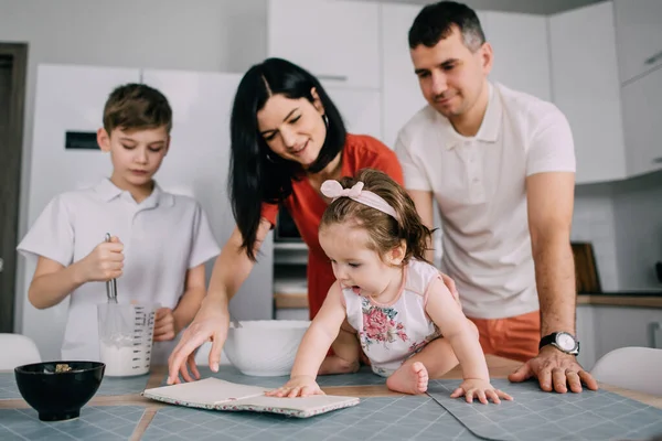 Familia joven preparando comida en la cocina en casa — Foto de Stock