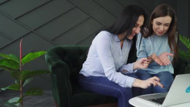 İki kız arkadaş internetten alışveriş yapıyor, Kara Cuma konsepti.