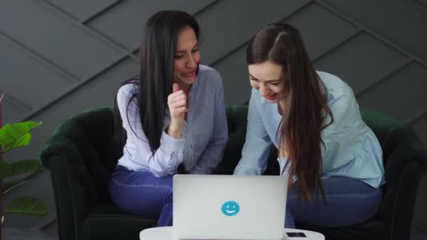 Dos mujeres felices mirando la pantalla del ordenador portátil y hablando animadamente — Vídeos de Stock