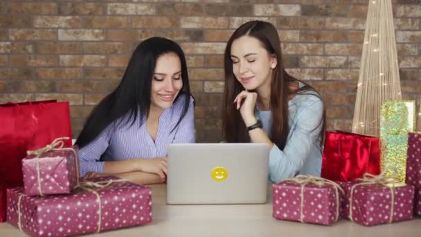 Две девушки выбирают рождественские подарки в Интернете — стоковое видео