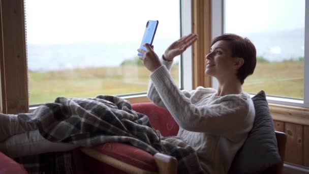 Mujer joven sonriente está haciendo videollamada en línea mirando la pantalla del teléfono inteligente — Vídeo de stock