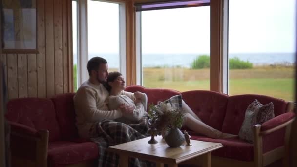 Lovers krama sitter på soffan i rummet, övergripande plan — Stockvideo