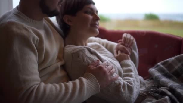 Para siedzi i przytula się na kanapie w domu, zbliżenie — Wideo stockowe