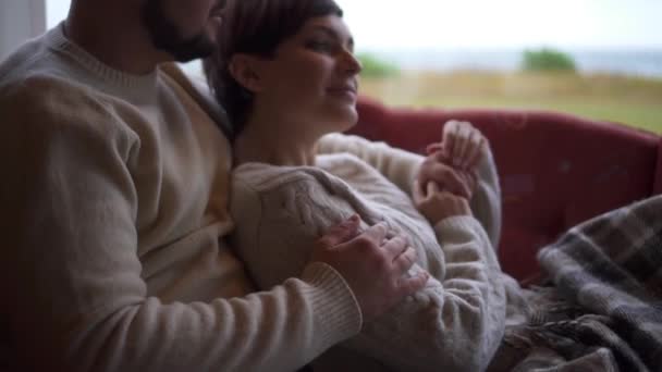 Par sitter och kramar på soffan hemma, närbild — Stockvideo