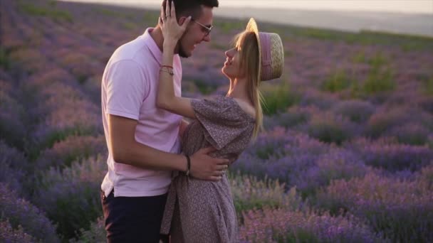 Два любовника обнимаются на цветущем лавандовом поле, крупным планом — стоковое видео