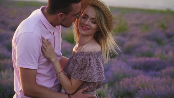 Молодая пара целуется в цветущем лавандовом поле, замедленная съемка — стоковое видео