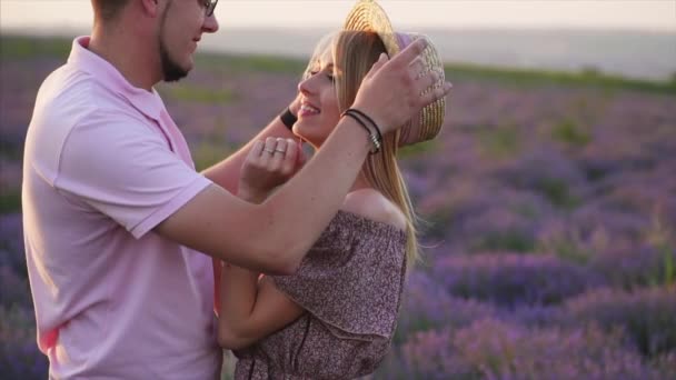 El hombre ajusta cuidadosamente su amado sombrero en el campo de lavanda al atardecer — Vídeo de stock