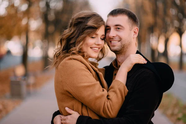 Romántica pareja joven abrazándose en el parque en un día de otoño —  Fotos de Stock