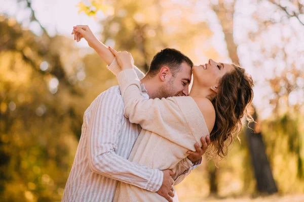 Чоловік цілує шию своєї коханої жінки в осінньому парку, крупним планом портрет — стокове фото