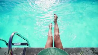 Mavi suda süzülen kadın bacaklarının yakın çekimi, yavaş çekim